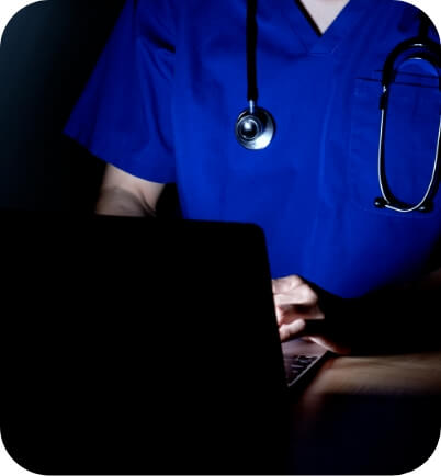 暗いところでパソコンをみている男性